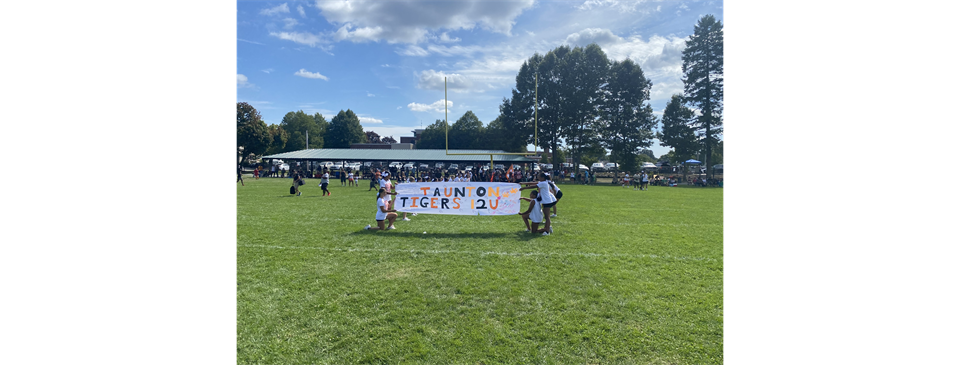 12u Cheerleaders holding their banner for the team to run through